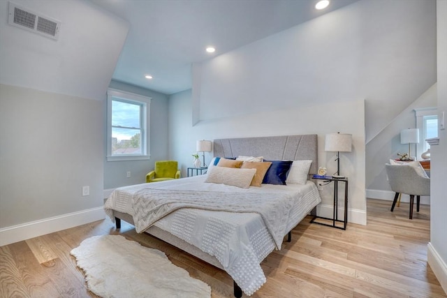 bedroom with light hardwood / wood-style floors and lofted ceiling