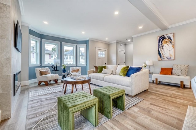 living room featuring beamed ceiling, light hardwood / wood-style floors, crown molding, and a fireplace