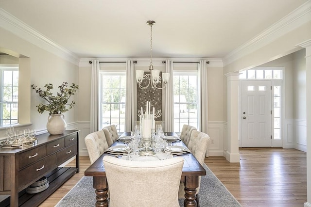 dining space featuring a healthy amount of sunlight, crown molding, and light hardwood / wood-style flooring