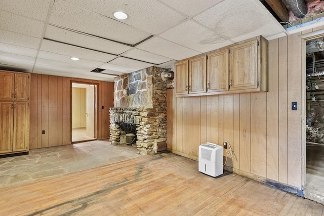 3 Cranberry Meadow Shore Rd, Charlton, MA 01507 - unfurnished living room with a paneled ceiling, wood walls, and light wood-style flooring