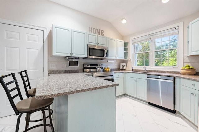 74 Hidden Bay Dr Unit 74, Dartmouth, MA 02748 - kitchen with stainless steel appliances, a peninsula, a kitchen bar, vaulted ceiling, and light marble finish floors