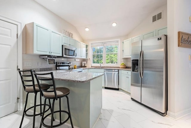 74 Hidden Bay Dr Unit 74, Dartmouth, MA 02748 - kitchen with stainless steel appliances, a peninsula, lofted ceiling, a kitchen bar, and tasteful backsplash