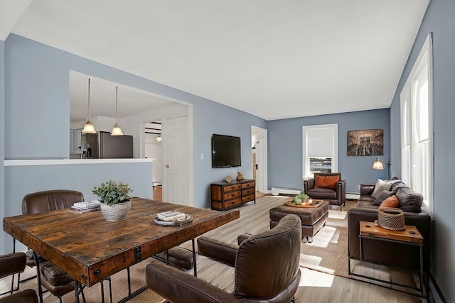 living room with light hardwood / wood-style flooring and a baseboard heating unit