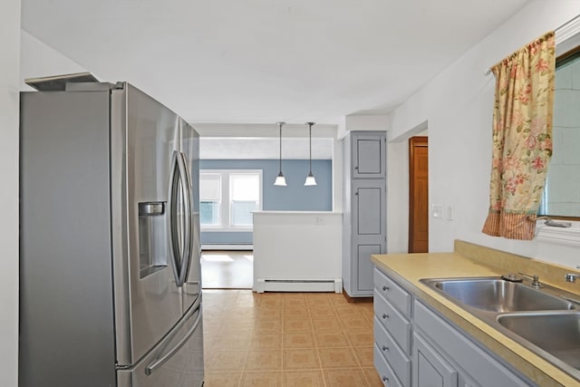 kitchen with pendant lighting, a baseboard heating unit, stainless steel fridge with ice dispenser, sink, and gray cabinetry