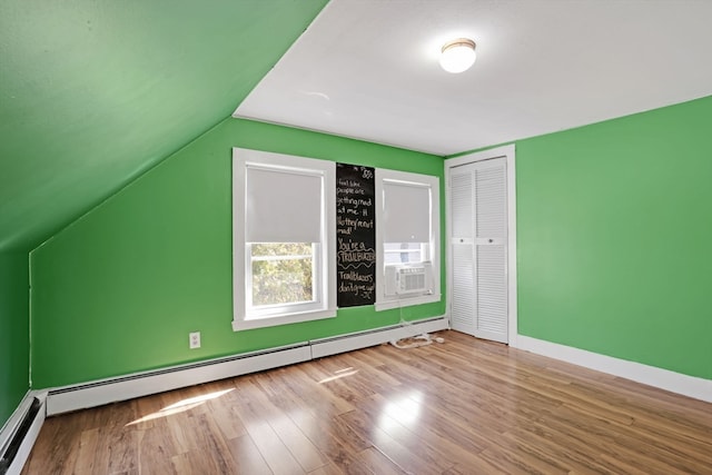 additional living space featuring a baseboard radiator, lofted ceiling, and hardwood / wood-style floors