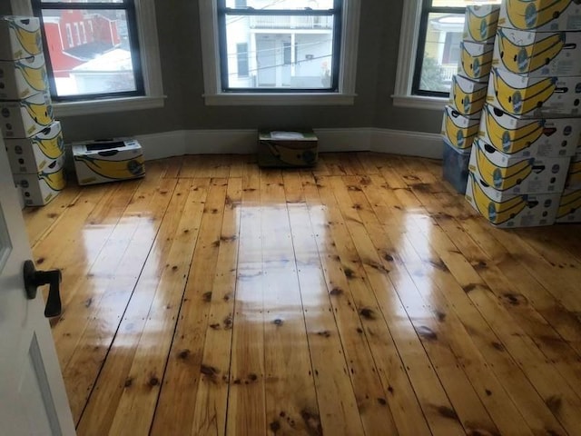 empty room with hardwood / wood-style floors and baseboards