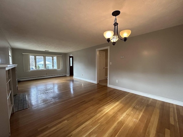 empty room featuring a notable chandelier, arched walkways, a baseboard radiator, baseboards, and dark wood-style flooring