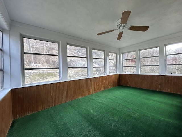 unfurnished sunroom featuring ceiling fan