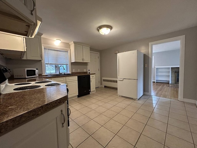 kitchen with white appliances, light tile patterned floors, radiator heating unit, a sink, and dark countertops