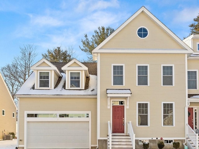 view of front of home with a garage and central AC