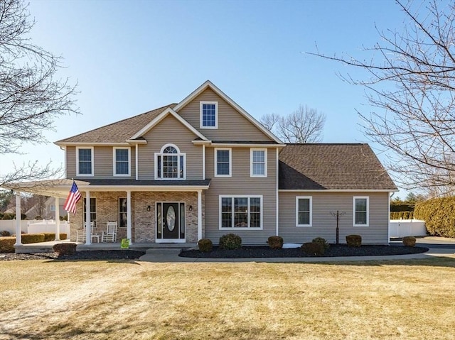 view of front of home with a porch, a front lawn, and fence