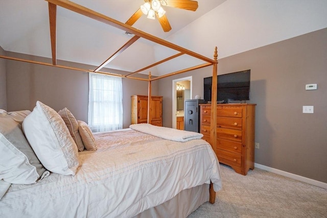 bedroom with lofted ceiling, connected bathroom, baseboards, light colored carpet, and ceiling fan