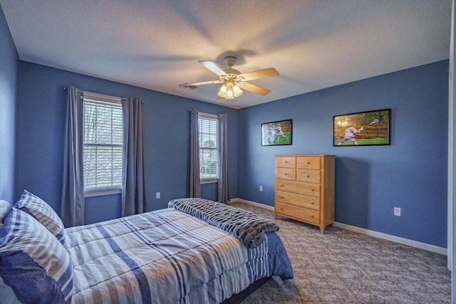 carpeted bedroom featuring ceiling fan, baseboards, and a textured ceiling