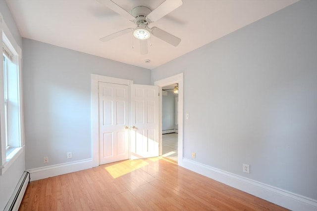 36 3rd St, Lowell, MA 01850 - unfurnished bedroom featuring a baseboard heating unit, light wood-style flooring, a closet, and ceiling fan
