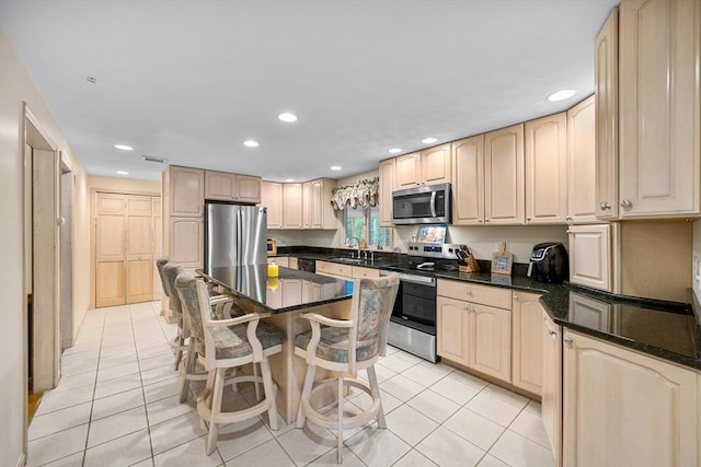 89 Gray St, North Andover, MA 01845 - kitchen with appliances with stainless steel finishes, light brown cabinets, light tile patterned floors, recessed lighting, and a kitchen breakfast bar