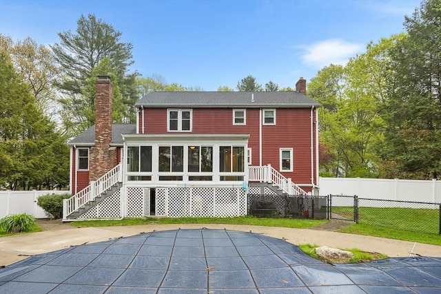 89 Gray St, North Andover, MA 01845 - rear view of house with a chimney, a sunroom, stairway, and a gate
