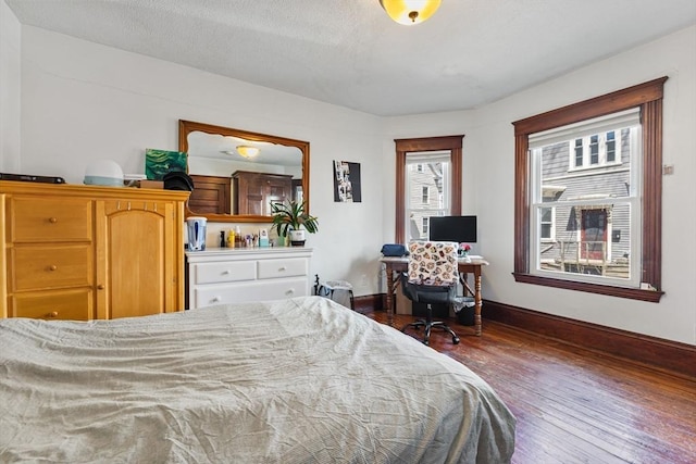 bedroom featuring baseboards and dark wood finished floors