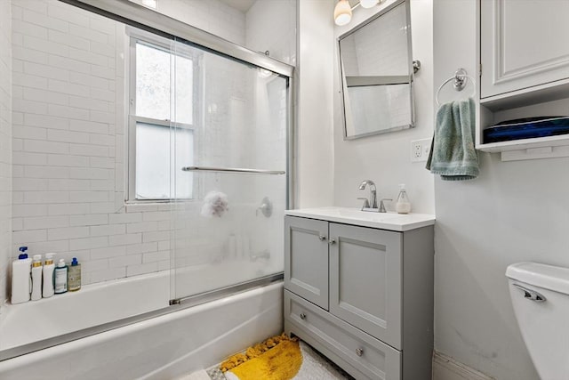 bathroom with shower / bath combination with glass door, toilet, and vanity