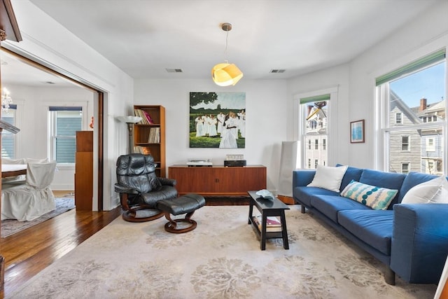 living area with wood finished floors and visible vents