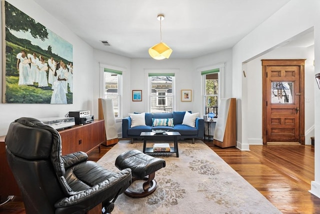 living room with visible vents, wood finished floors, and a healthy amount of sunlight