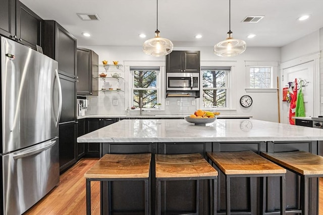 kitchen with visible vents, light wood-type flooring, a wealth of natural light, and stainless steel appliances