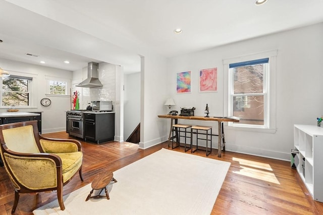 living area featuring baseboards, recessed lighting, wood finished floors, and visible vents