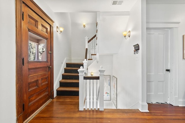 entryway featuring stairs, baseboards, visible vents, and wood finished floors