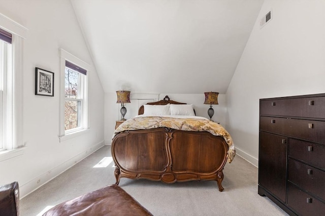 bedroom with baseboards, visible vents, light colored carpet, and lofted ceiling