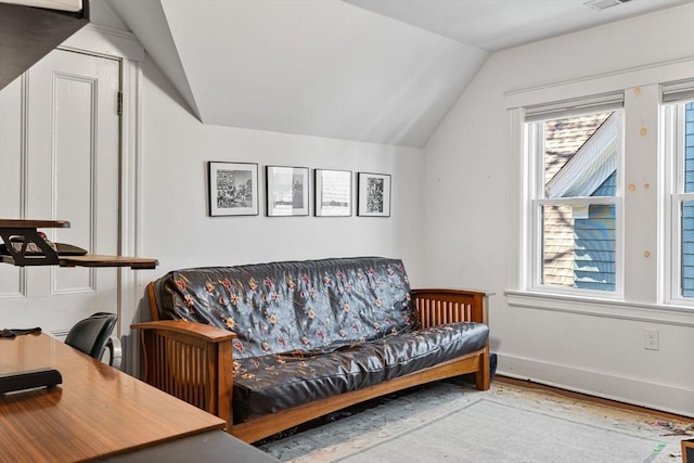 living room with wood finished floors, baseboards, and lofted ceiling
