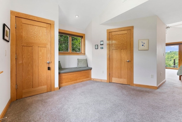 entrance foyer with light carpet, vaulted ceiling, and ceiling fan