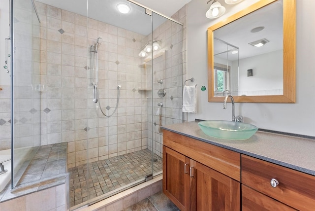 bathroom featuring tile patterned flooring, an enclosed shower, and vanity