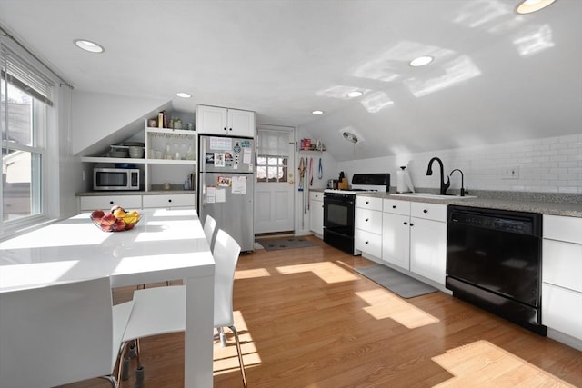 kitchen featuring lofted ceiling, sink, light hardwood / wood-style flooring, stainless steel appliances, and white cabinets