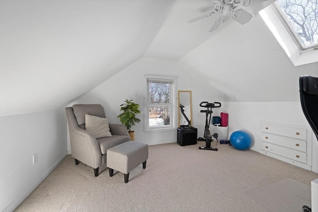 sitting room with light colored carpet, lofted ceiling with skylight, and ceiling fan