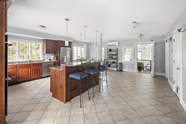 kitchen with light stone counters, light tile patterned flooring, a kitchen breakfast bar, appliances with stainless steel finishes, and a wall mounted AC