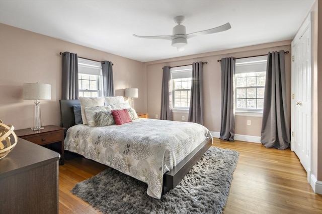 bedroom featuring baseboards, ceiling fan, and light wood finished floors