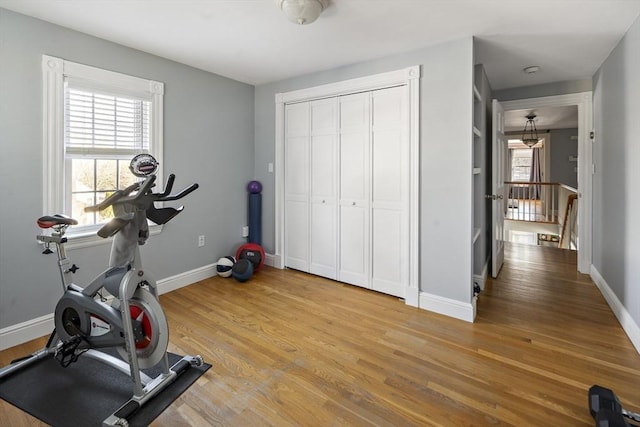 workout room featuring light wood-type flooring and baseboards