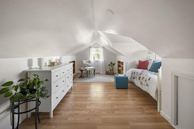 bedroom featuring light wood-style floors and vaulted ceiling