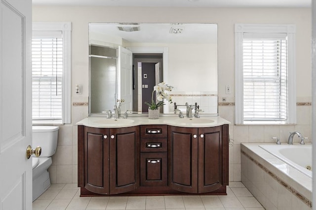 bathroom featuring visible vents, a sink, and tile walls