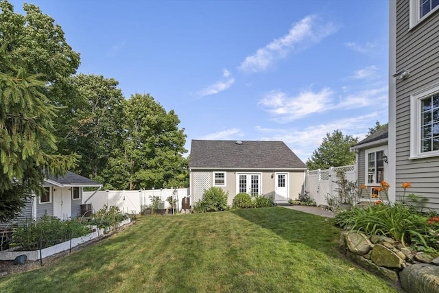 view of front of home featuring a fenced backyard, a front lawn, and an outbuilding