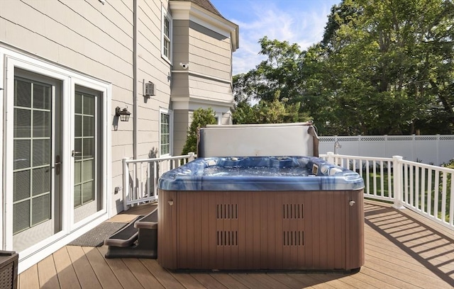 wooden terrace with fence and a hot tub