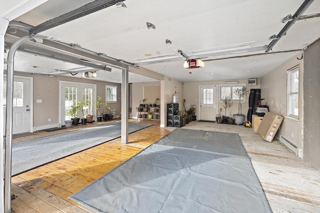 garage with baseboards, french doors, baseboard heating, and a garage door opener