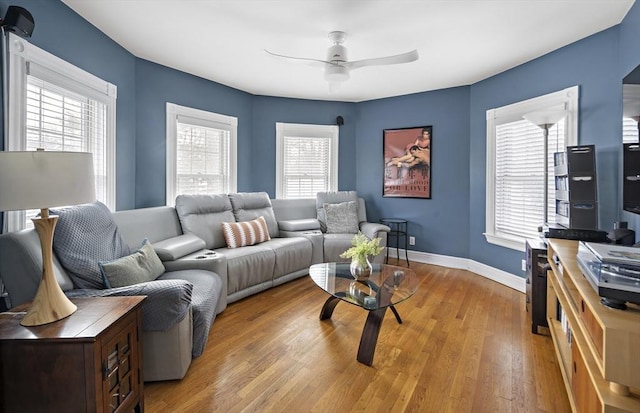 living area with ceiling fan, light wood-type flooring, and baseboards