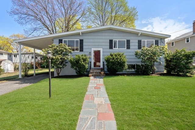 view of front of house with entry steps, driveway, and a front yard