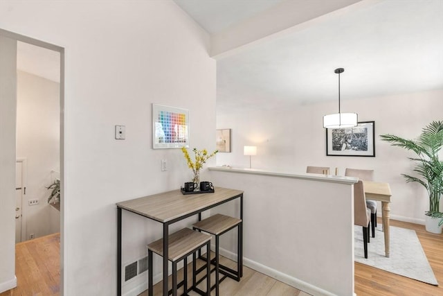 corridor featuring baseboards and wood finished floors