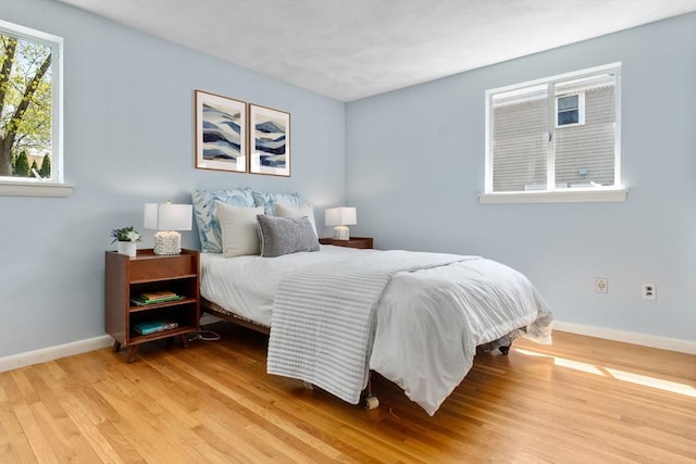 bedroom with baseboards and light wood-type flooring