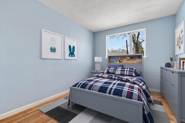 bedroom with light wood-style floors and baseboards
