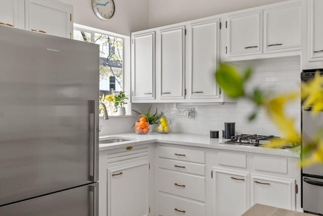 kitchen with light countertops, white cabinetry, backsplash, and stainless steel appliances