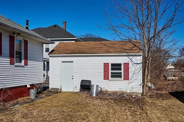 view of property exterior with a yard and roof with shingles