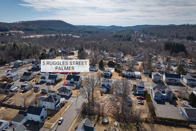 drone / aerial view with a mountain view, a wooded view, and a residential view