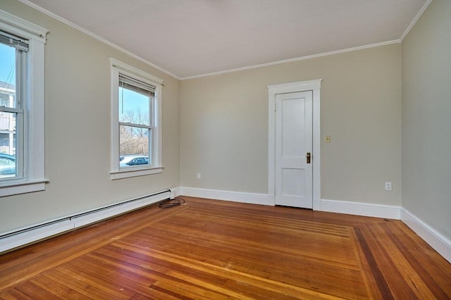 spare room featuring wood finished floors, baseboards, baseboard heating, and ornamental molding